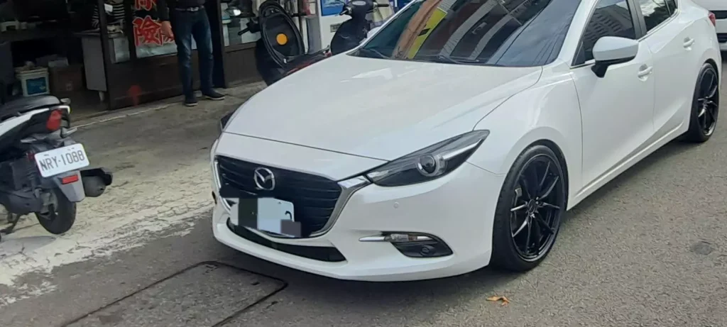 白色改裝車停在驗車達人店前並呈現降低車身姿態